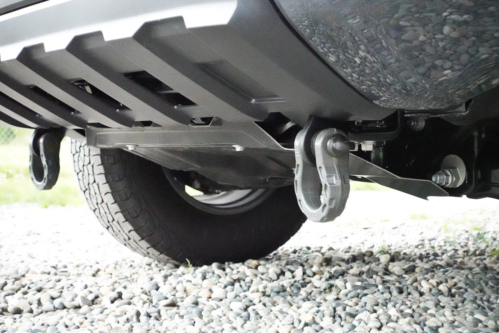 Close-up view of heavy-duty BPF 2024+ Tacoma Recovery Points mounted on the underside of a truck near the rear tire, designed for secure towing and recovery.