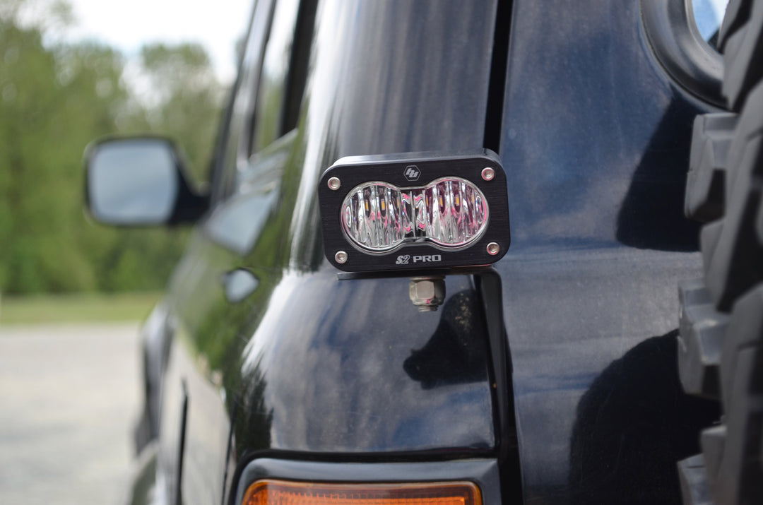Close-up of a mounted auxiliary LED light attached to a black vehicle using BPF 80 series Land Cruiser rear light brackets 92-97, designed for durable and secure rear light installation.