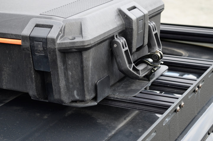 BPF Universal Pelican Vault V700 Case Mounting brackets securely hold a rugged Pelican Vault V700 case on a durable metal rack, showcasing heavy-duty CNC fabricated overlanding gear.