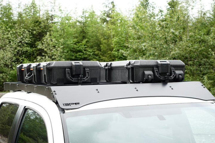 BPF Universal Pelican Vault V800 and V730 Case Mounting brackets securing two black protective cases on a truck roof rack, designed for overlanding gear storage and heavy-duty use.