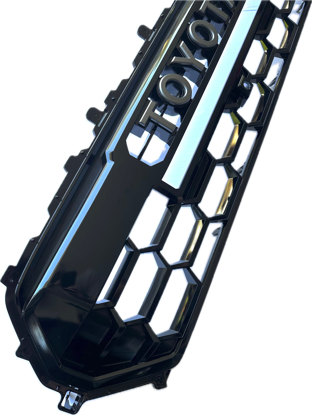 Close-up of a glossy black 2024 TRD Pro Heritage Grille with BPF letters featuring a honeycomb mesh pattern and bold raised lettering.