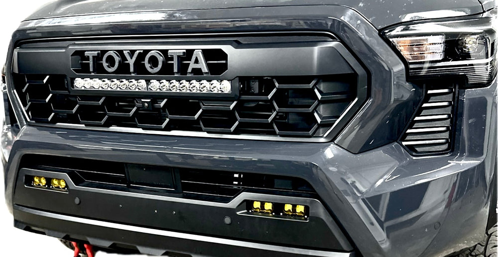 Front view of a dark gray truck featuring the 2024 TRD Pro Heritage Grille with BPF letters and integrated LED light bar in the grille center.