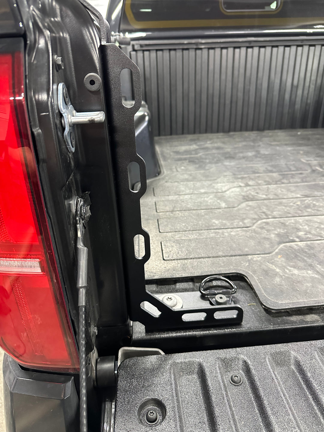 Close-up view of black metal BPF 2024-2025 Toyota Tacoma Bed Stiffeners installed on the truck bed corner, showcasing durable powder-coated CNC fabricated design.