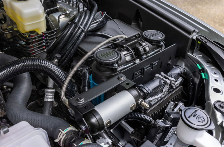 Close-up of a BPF 2025+ 4runner twin compressor mount installed in an engine bay, showing black powder-coated compressor mounts and connected air lines.