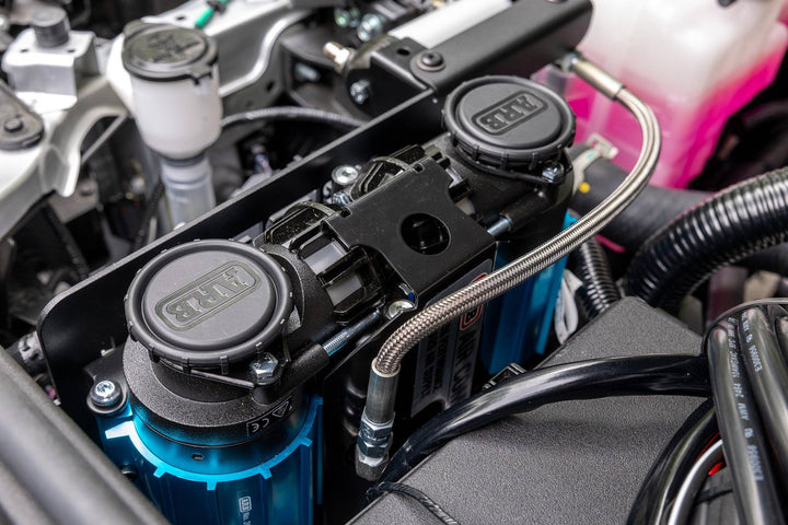 Close-up of a BPF 2025+ 4runner twin compressor mount installed in an engine bay, showing durable CNC fabricated metal components and robust fittings for overlanding gear.