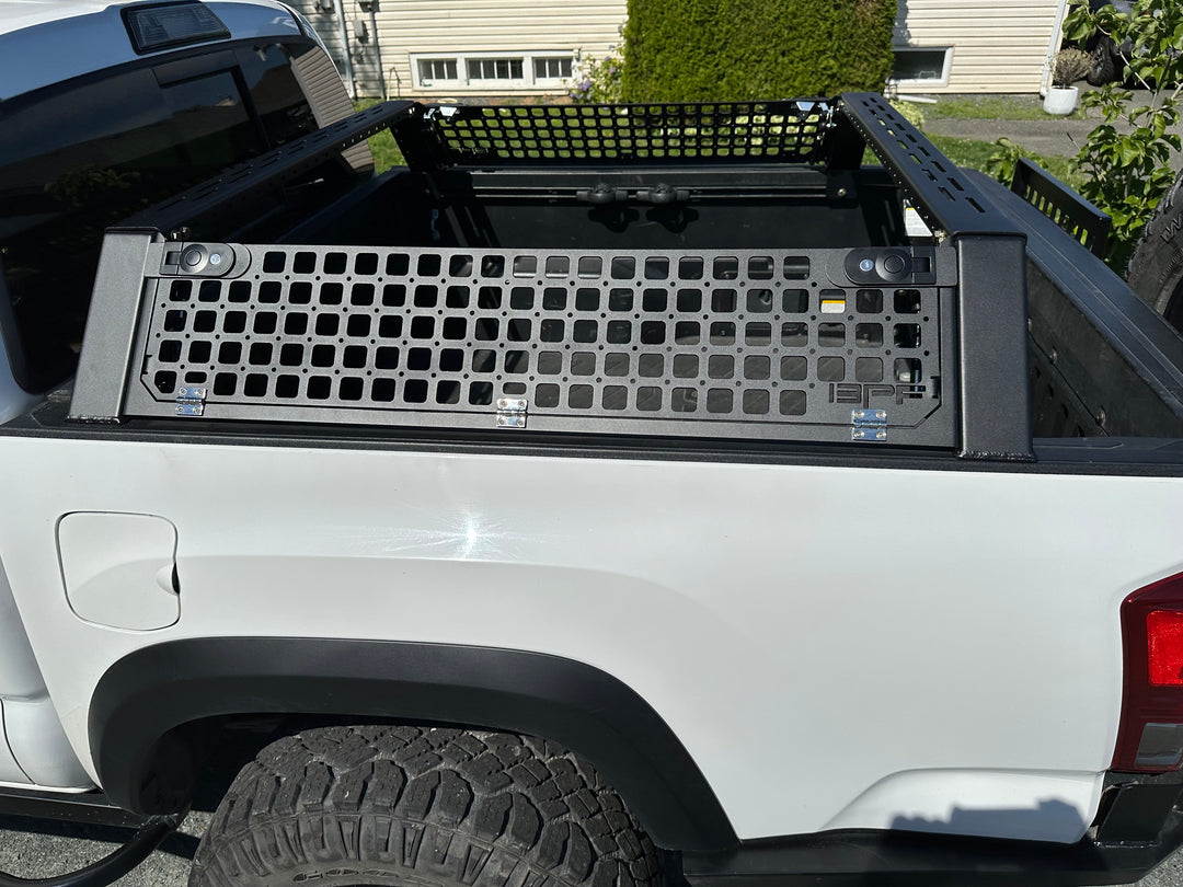05-26 Tacoma Bed Rack fits 2nd,3rd and 4th gen Tacomas installed on a white truck, featuring a black powder-coated grid panel for versatile mounting and storage options.