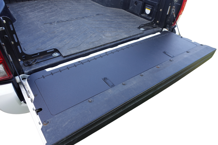 BPF 2016-2023 Toyota Tacoma Tailgate Panel installed on open truck tailgate, showing durable black powder-coated metal surface with secure mounting hardware.
