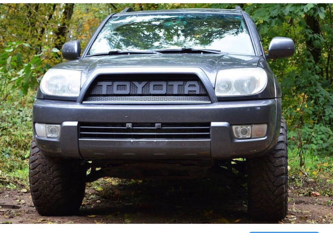 Front view of a Toyota 4Runner featuring a black BPF 03-09 Toyota 4runner Grill with bold TOYOTA lettering, showcasing a rugged and durable design suited for off-road and overlanding enthusiasts.