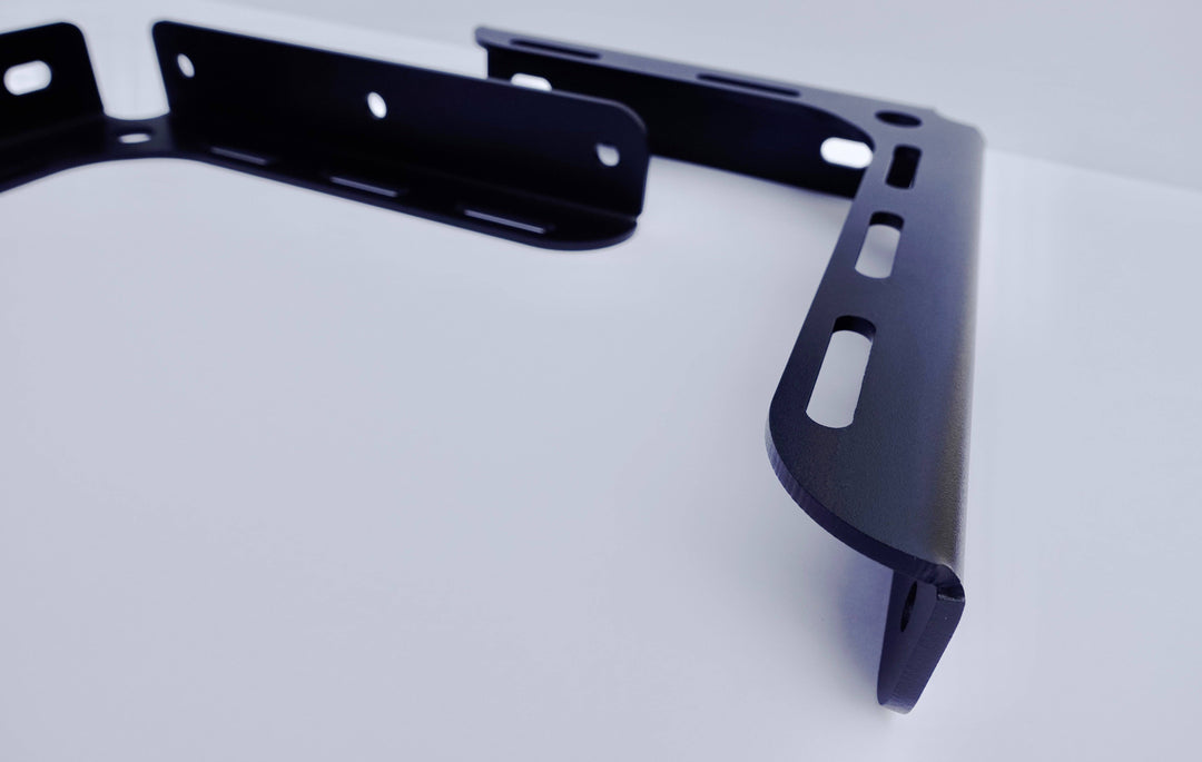 Close-up view of a black powder-coated BPF 2005-2023 Toyota Tacoma Bed Stiffeners bracket showcasing its CNC fabricated steel construction and OEM fitment design.