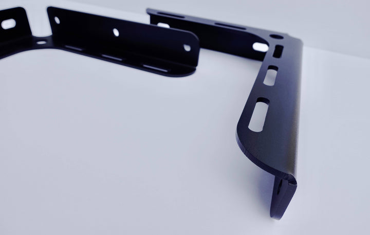 Close-up view of a black powder-coated BPF 2005-2023 Toyota Tacoma Bed Stiffeners bracket showcasing its CNC fabricated steel construction and OEM fitment design.