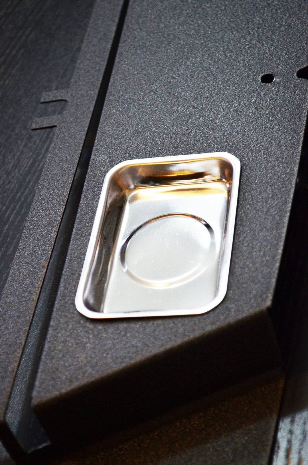 Close-up view of a polished metal insert on the textured surface of the BPF 05-11 Toyota Tacoma Radiator Cover, showcasing CNC fabricated, powder coated finish for durable Tacoma accessories.