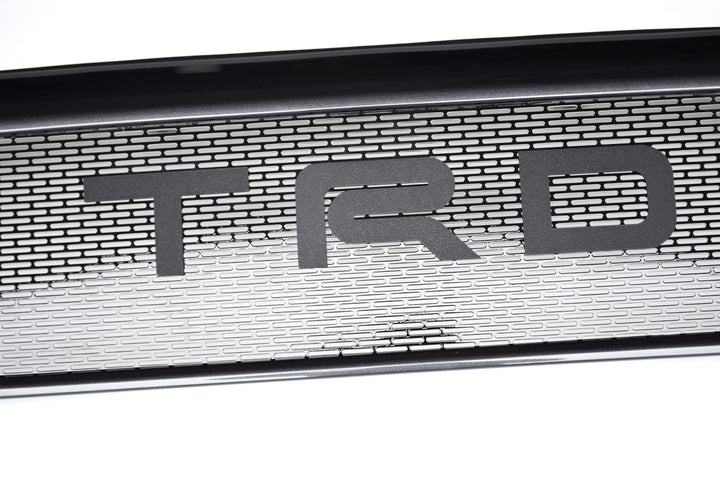 Close-up of the BPF 2012-2015 Toyota Tacoma Mesh and Lettering showcasing a black mesh grille with bold TRD lettering for enhanced truck front-end styling and durability.