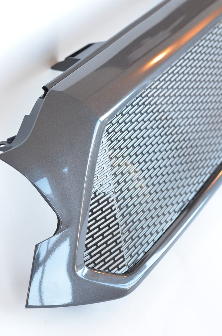Close-up of a metallic gray mesh grille with geometric pattern and frame, designed as the BPF 2012-2015 Toyota Tacoma Mesh and Lettering accessory for truck customization.
