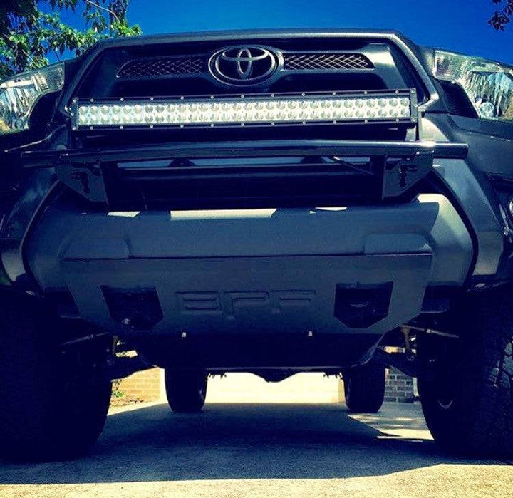 Front view of a black Toyota Tacoma outfitted with a BPF 2005-2015 Toyota Tacoma Skid Plate, featuring durable construction and a custom fit for rugged off-road protection.