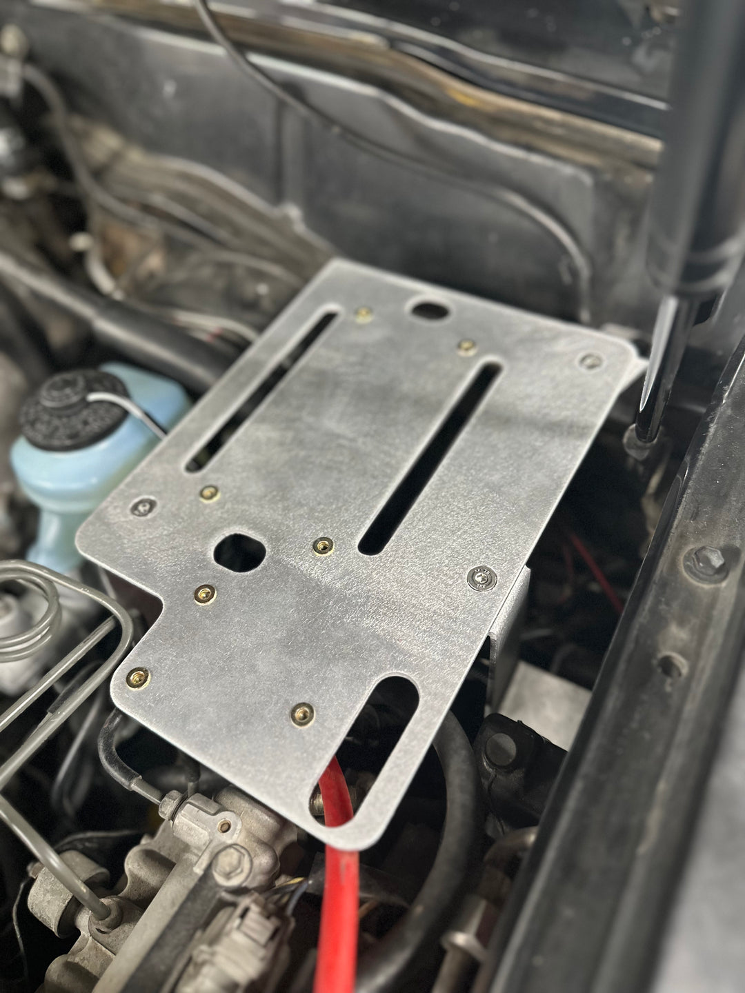 BPF 80 series Land cruiser Fuse block mount securely installed in engine bay, featuring durable metal construction and strategic mounting points for OEM fitment and easy installation.