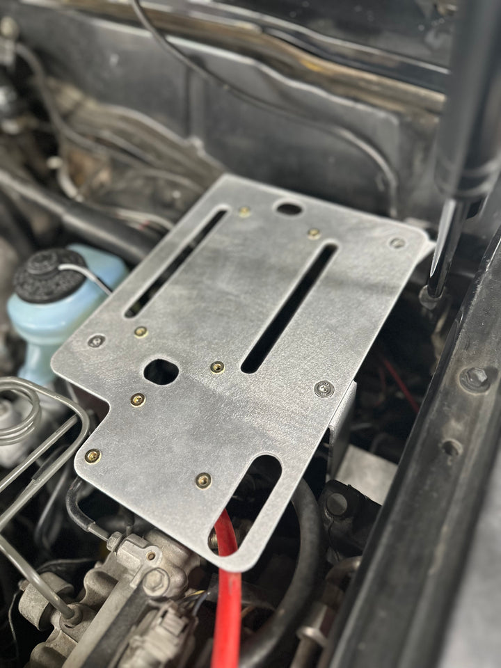 BPF 80 series Land cruiser Fuse block mount securely installed in engine bay, featuring durable metal construction and strategic mounting points for OEM fitment and easy installation.