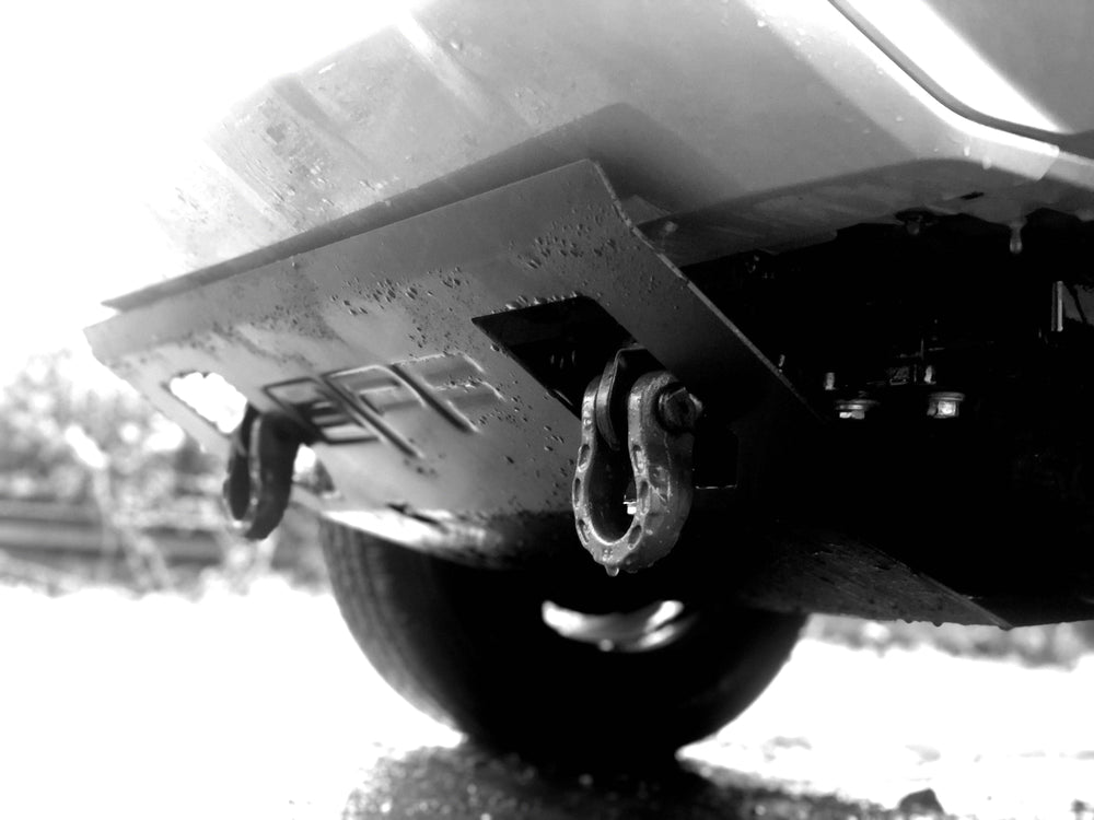 Underneath a vehicle, a heavy duty BPF 2005-2023 HD Tacoma Recovery Tow Hook mounted on the front bumper, designed for reliable towing and recovery in rugged conditions.