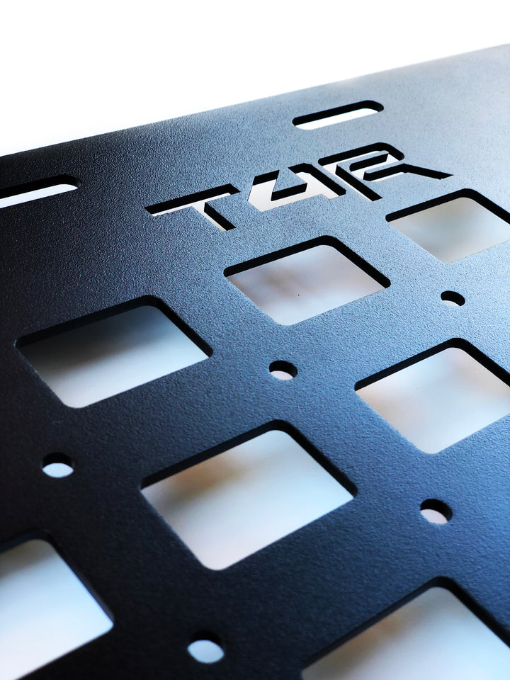 Close-up of a black powder-coated metal panel with precision cutouts and the T4R logo, designed as BPF 2010-2024 4Runner Storage Panels for durable overlanding gear storage solutions.