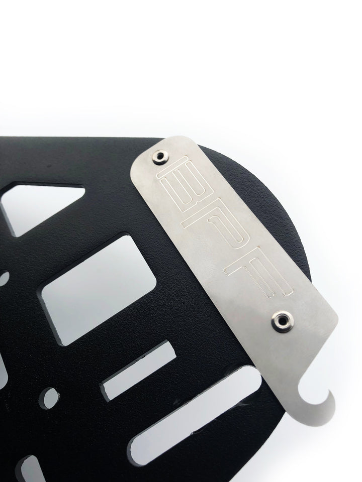 Close-up of a black powder-coated metal panel with cutouts and a silver engraved plate featuring BPF, part of the BPF 2010-2024 4Runner Storage Panels designed for durable overlanding gear.