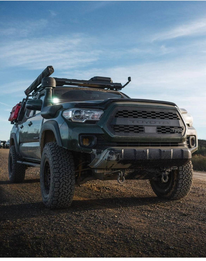 Off-road Toyota Tacoma equipped with a BPF 2016-2023 Toyota Tacoma Grill featuring a rugged black honeycomb mesh design and enhanced front-end durability.